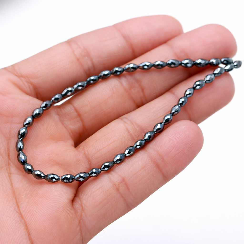 Silver chain held in a hand against a white background