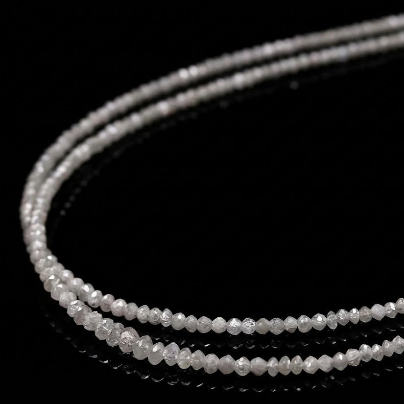 Close-up of a string of small, round, clear beads on a black background