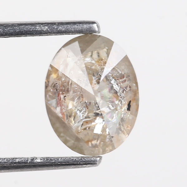 Diamond held between two metal prongs against a white background