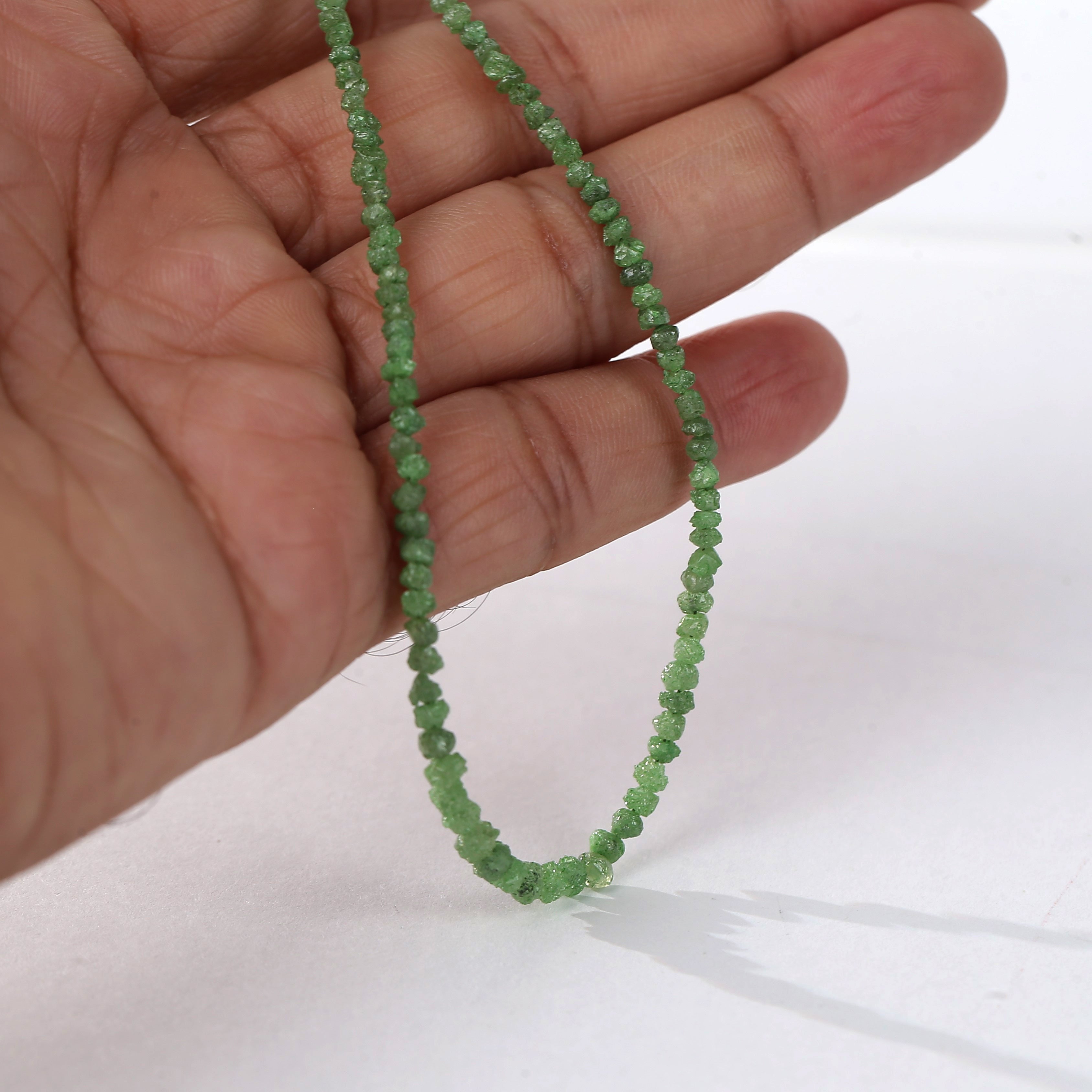 Small faceted rough green diamond beads looped on string