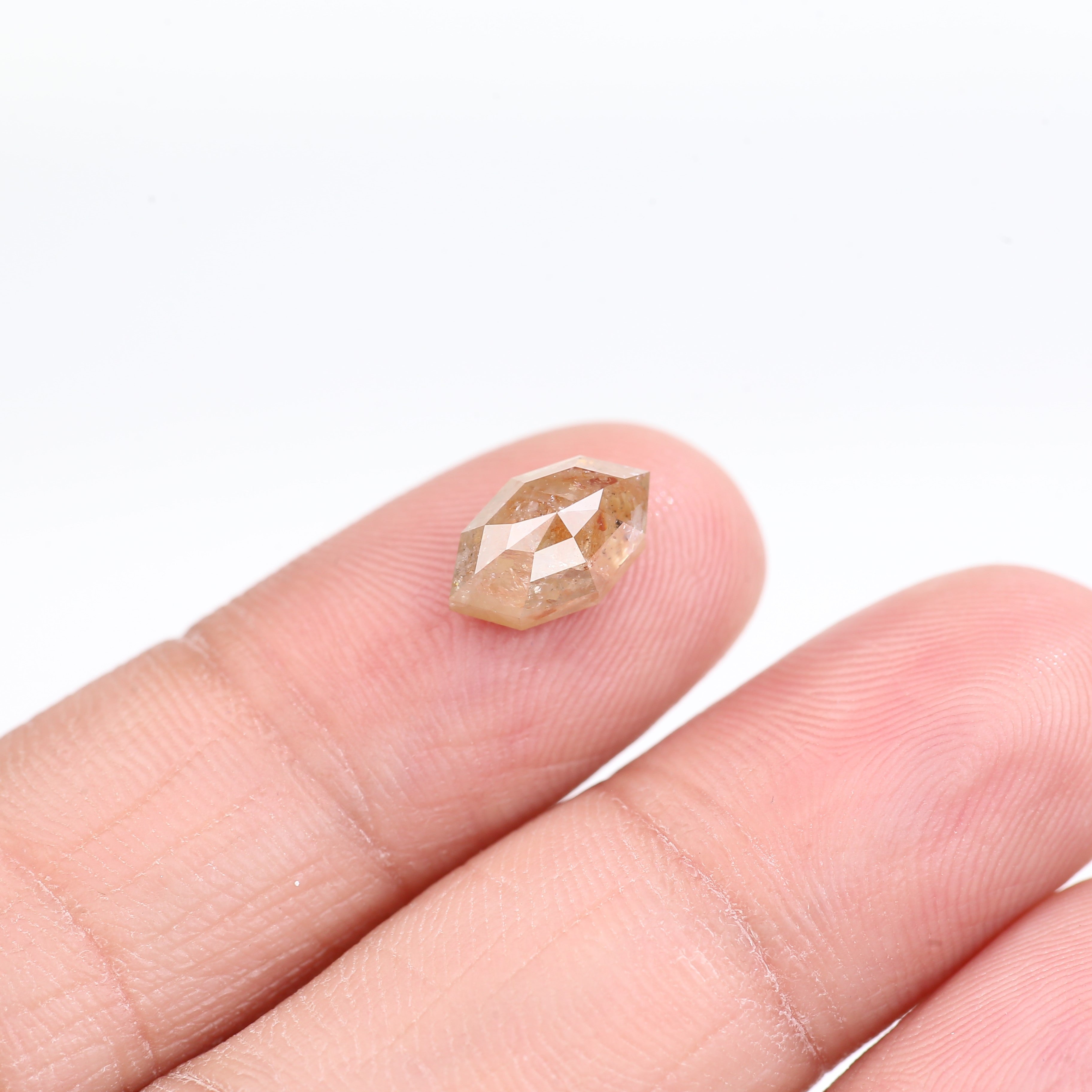 Diamond held between fingers on a white background
