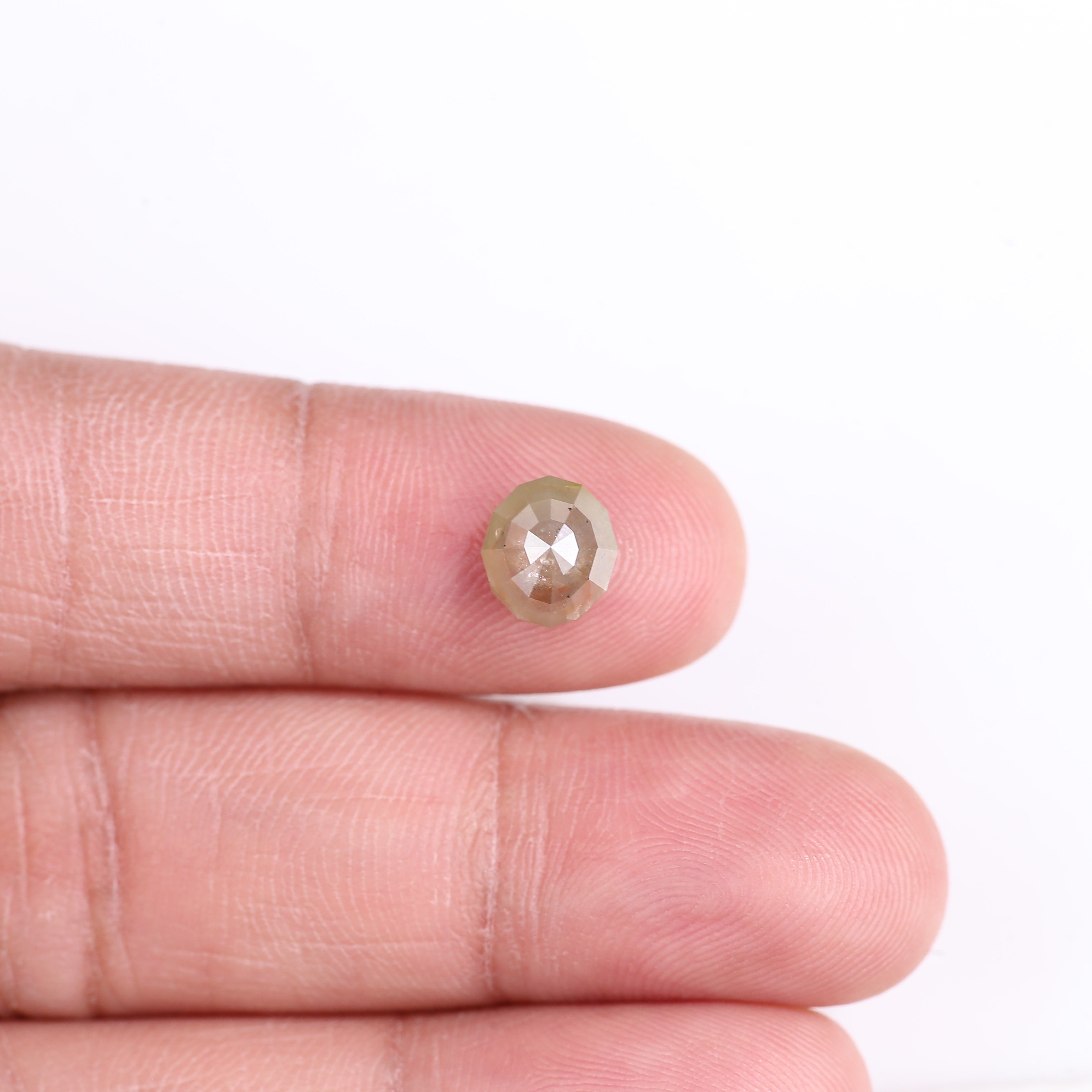 Diamond held between two fingers against a white background