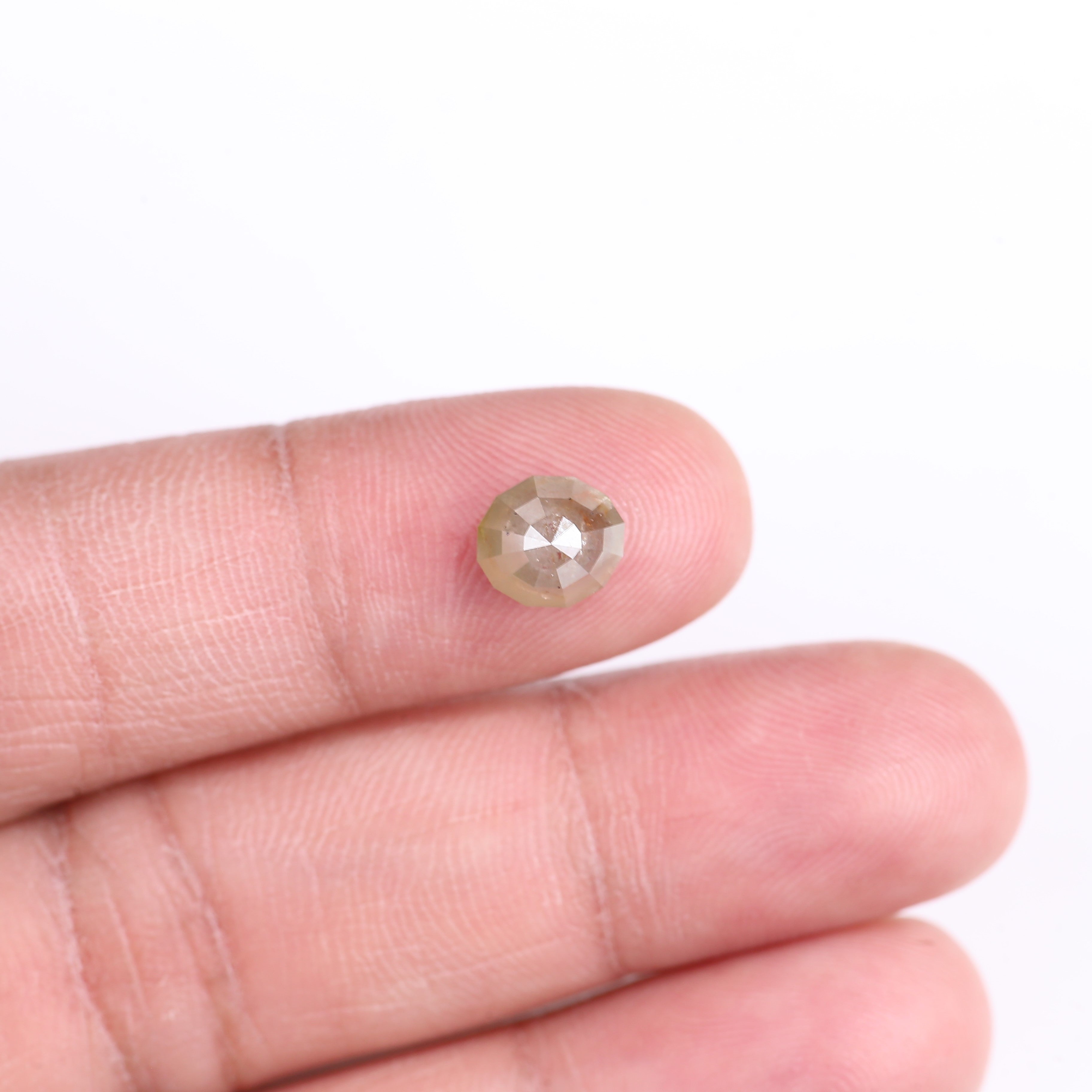 Diamond held between fingers on a white background