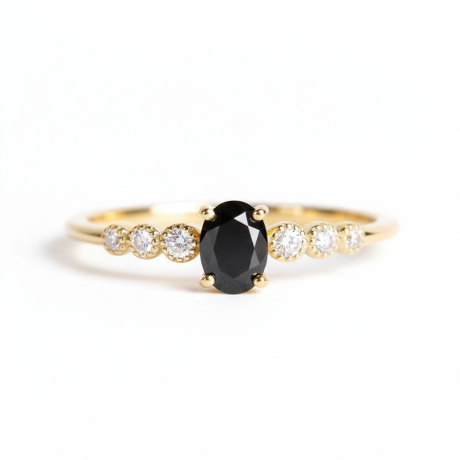 Gold ring with a black diamond and smaller diamonds on a white background