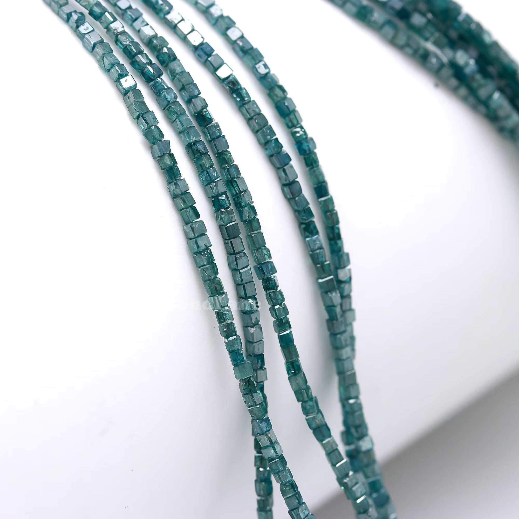 Close-up of green beaded strands on a white background