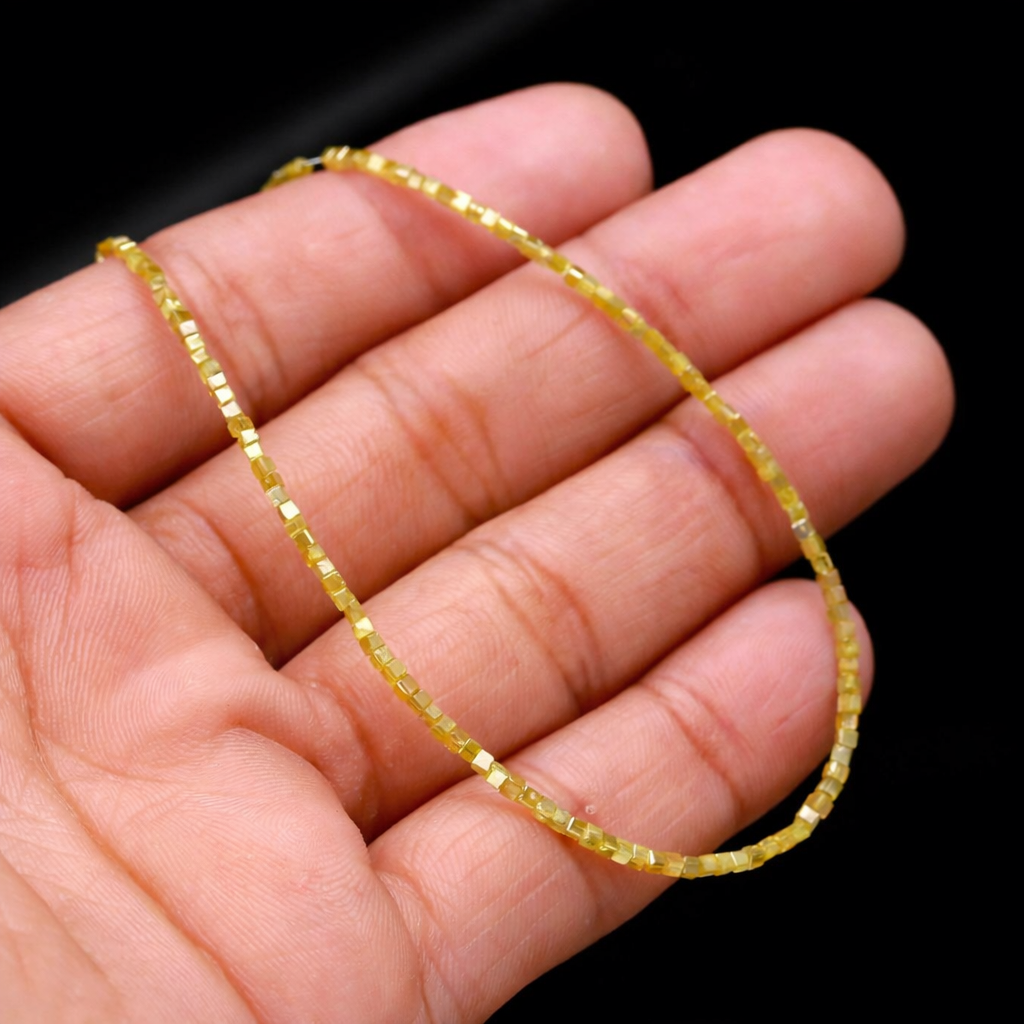 Yellow gemstone necklace on a hand against a black background