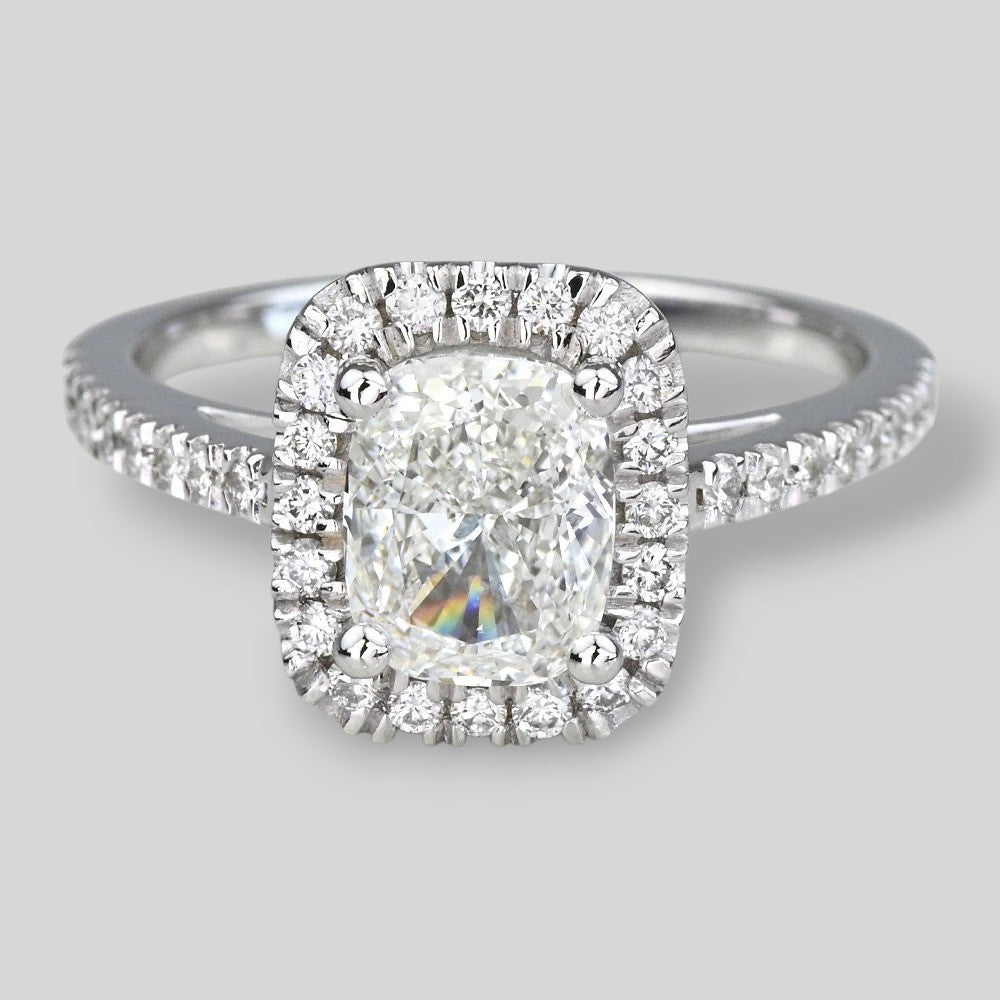 Diamond ring with a halo on a light gray background