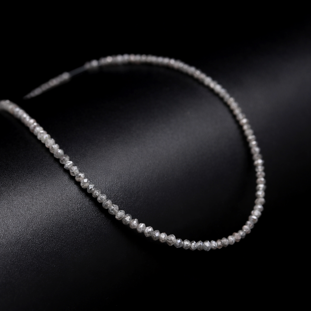 Silver beaded necklace on a dark surface