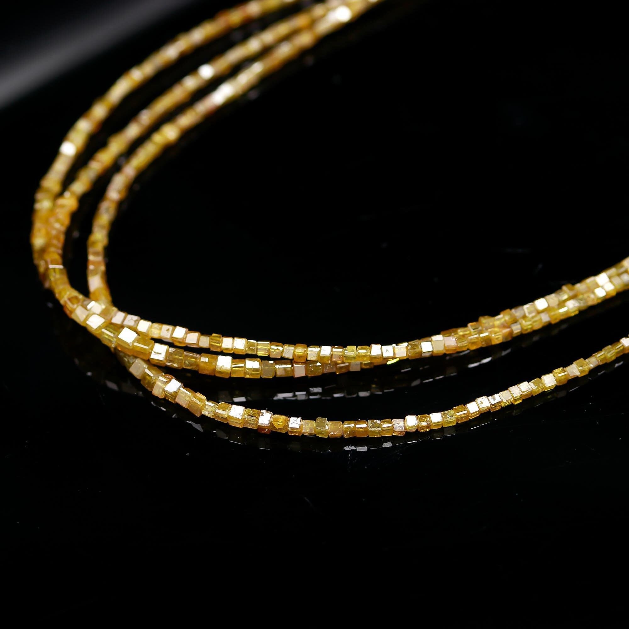 Gold beaded strands on a black background
