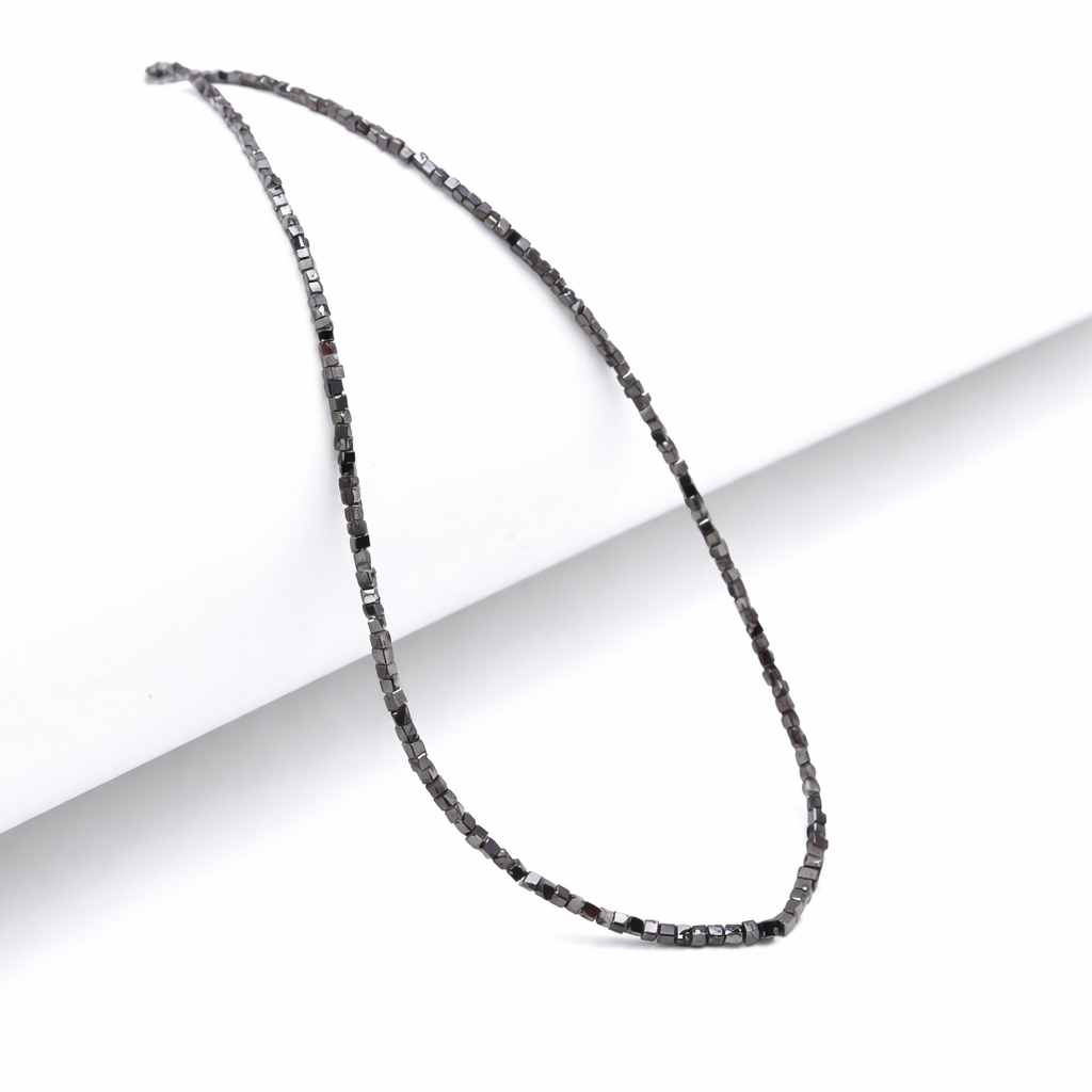 Necklace with small, dark beads on a white background