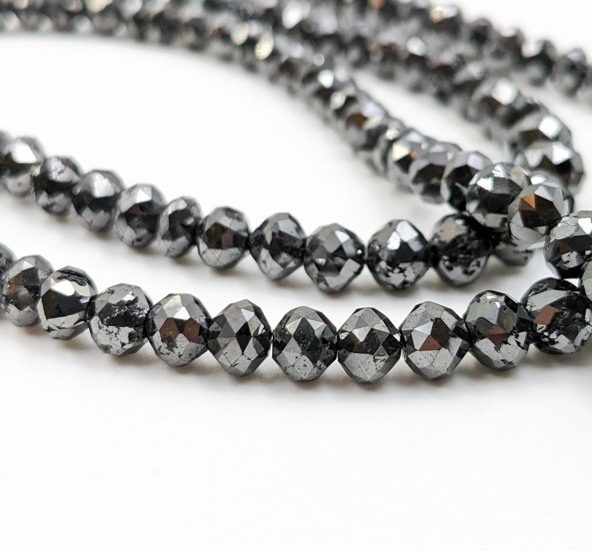 Close-up of black faceted beads on a white background