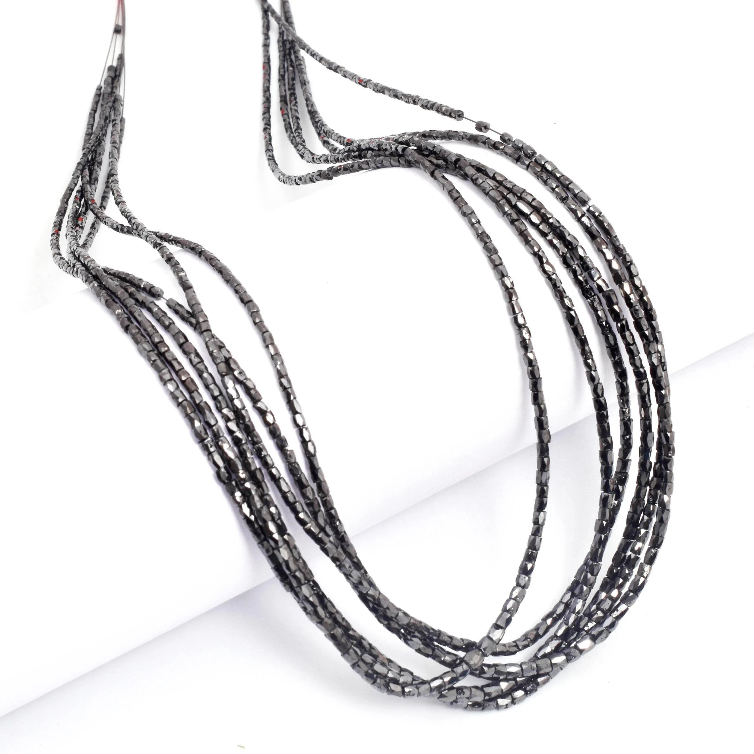 Multi-strand black beaded necklace on a white background