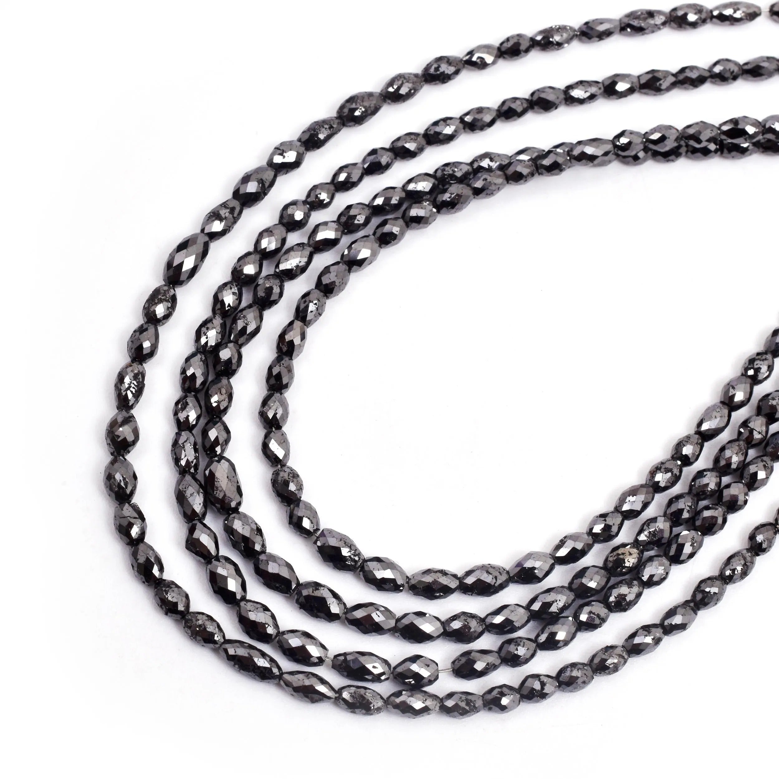 Three strands of black faceted beads on a white background