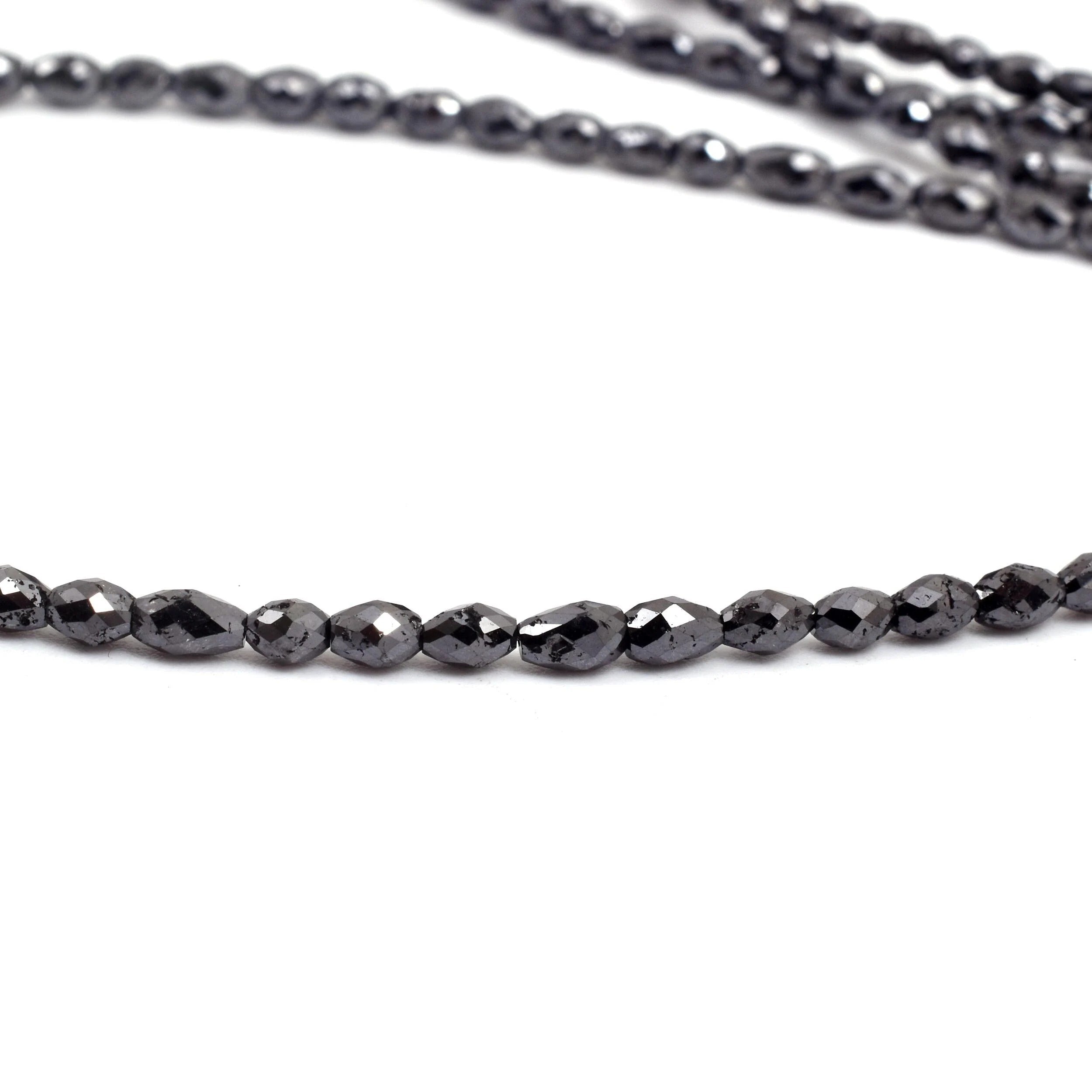 Close-up of a black beaded necklace on a white background
