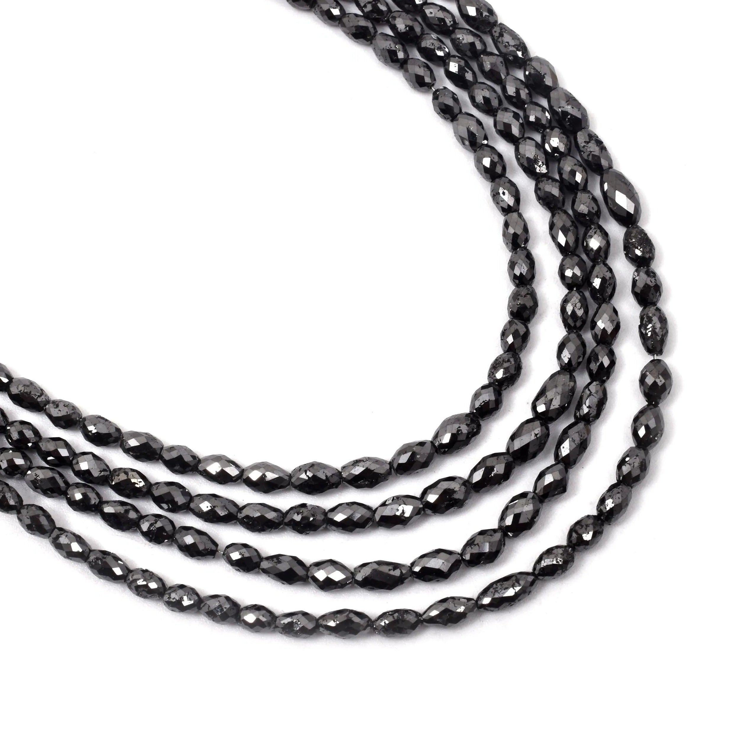 Three strands of black faceted beads on a white background
