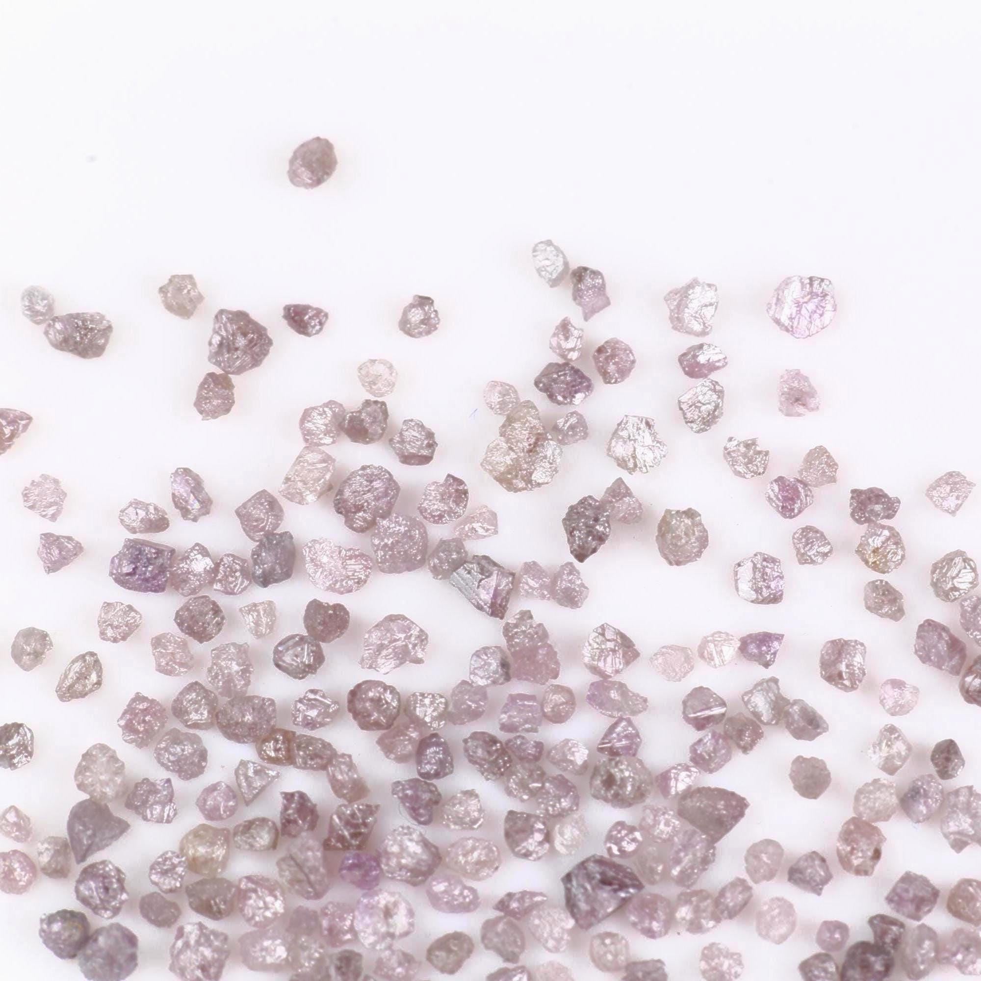 Raw diamonds scattered on a white background