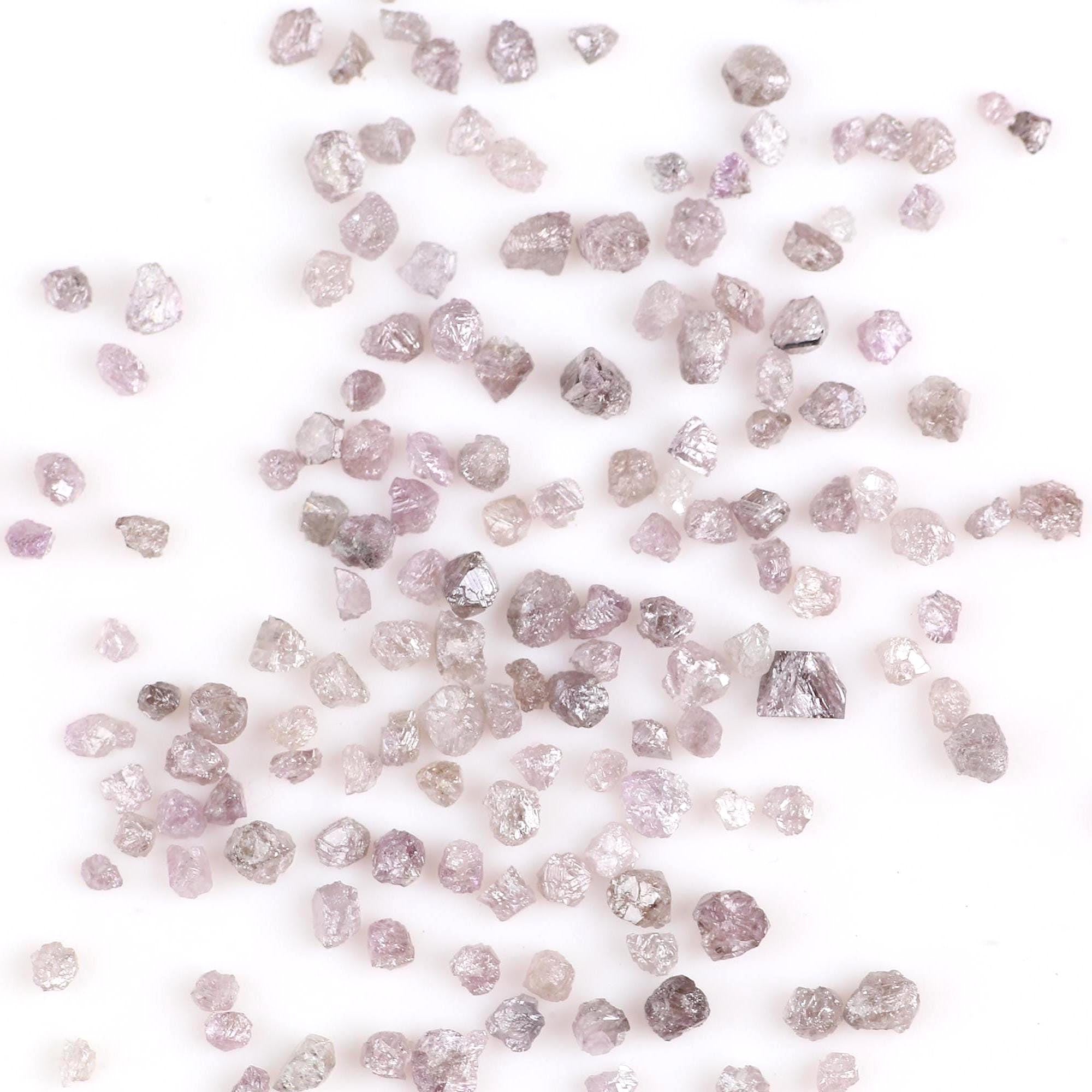 Raw diamonds scattered on a white background