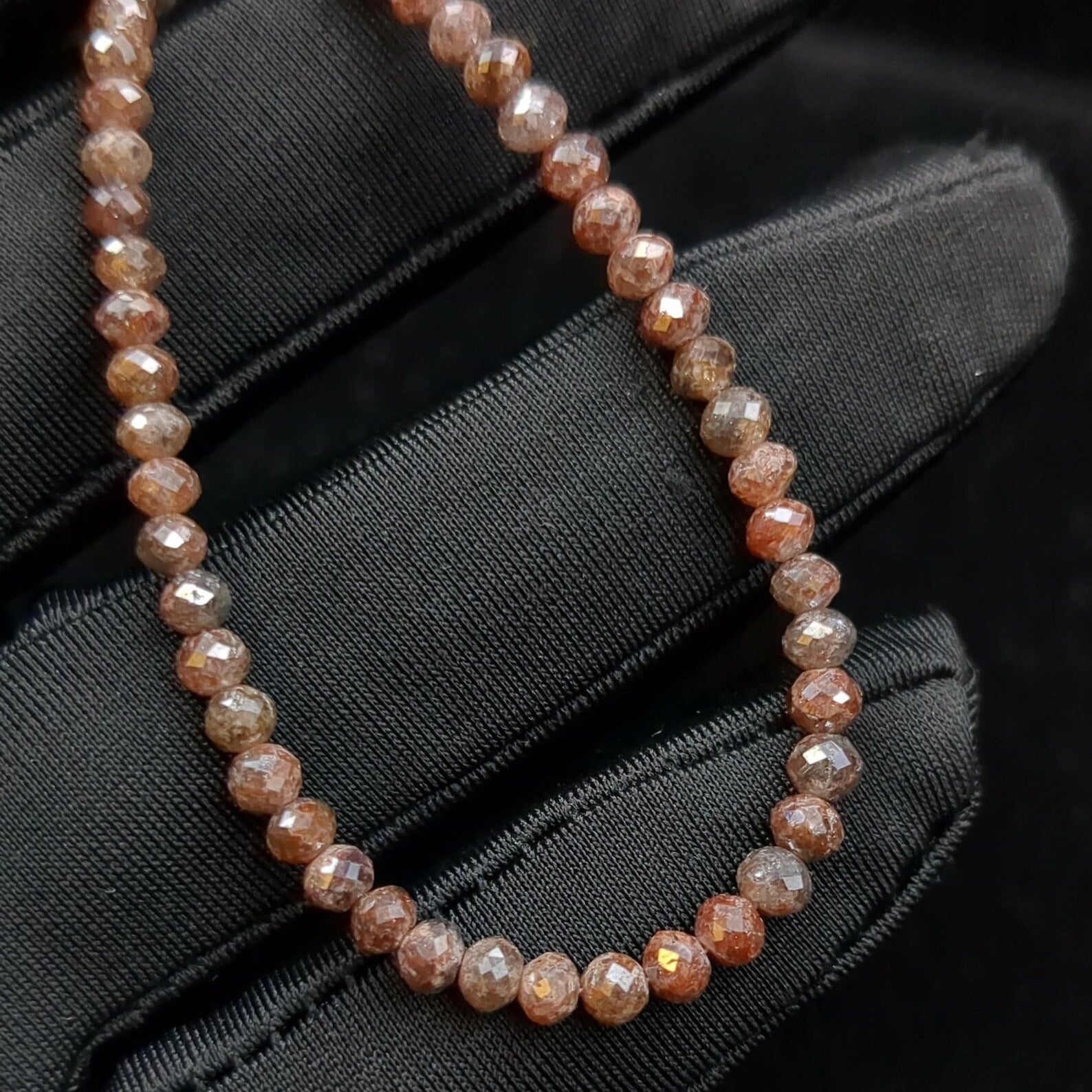 Necklace with brown beads on a black fabric background