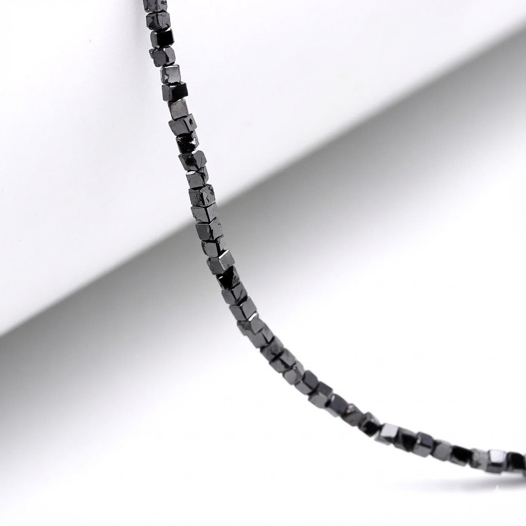 Close-up of a black beaded necklace on a white background